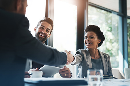 Smiles and handshakes in a non-descript stock photo office